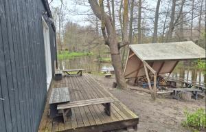 a wooden deck with a picnic table and a tent at Zilvitis in Karklė