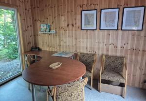 a wooden room with a wooden table and chairs at Zilvitis in Karklė