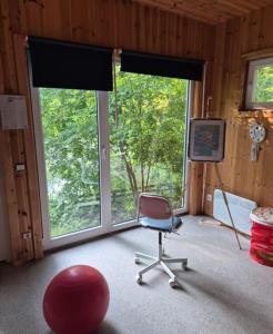 a room with a chair in front of a window at Zilvitis in Karklė