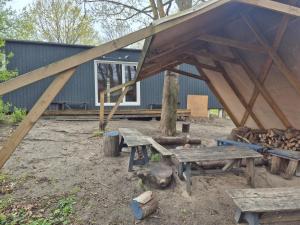 a group of picnic tables and a building at Zilvitis in Karklė +1 photo
