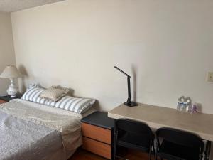 a bedroom with a bed and a desk with chairs at Palm Cabin in San Gabriel +4 photos