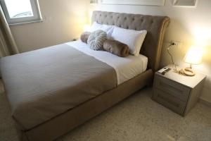 a bedroom with a large bed and a night stand with a lamp at Alcenide Aparthotel in Villa San Giovanni