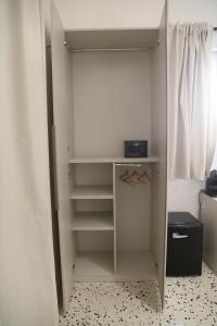 a white closet with a shelf and a window at Alcenide Aparthotel in Villa San Giovanni