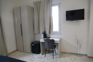 a desk with a chair and a television in a room at Alcenide Aparthotel in Villa San Giovanni