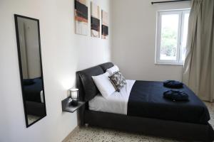 a bedroom with a black bed and a mirror at Alcenide Aparthotel in Villa San Giovanni +49 photos