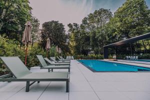 a row of lounge chairs next to a swimming pool at Stars Resort Sigulda in Sigulda