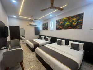 a hotel room with two beds and a tv at Hotel Shree Kesari Nandan in Dwarka