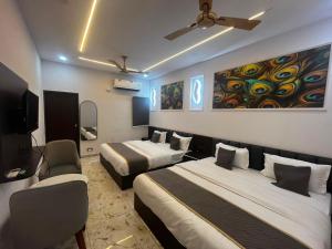 a hotel room with two beds and a tv at Hotel Shree Kesari Nandan in Dwarka