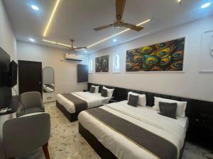 a hotel room with two beds and a tv at Hotel Shree Kesari Nandan in Dwarka +18 photos