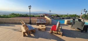 a group of chairs sitting on a patio with a pool at Casale Ciricó tra Catania e Siracusa in Carlentini