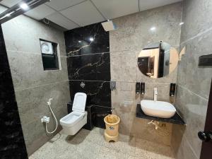 a bathroom with a toilet and a sink and a mirror at Hotel Shree Kesari Nandan in Dwarka
