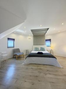 a bedroom with a large bed and a table and chairs at Anemos Mill House in Imerovigli +62 photos