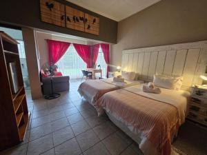 a hotel room with two beds and a television at Aqua Terra Guest House in Lydenburg +42 photos