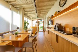 a restaurant with wooden tables and chairs and a clock on the wall at Guest House Aura - Lumys Fiumicino in Fiumicino