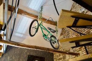 a green bike hanging from a ceiling at Loft urbain style Brooklyn in Profondeville