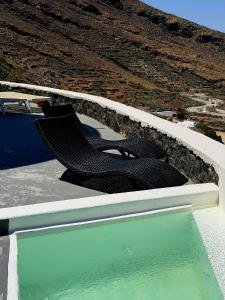 two chairs sitting on top of a pool of water at Anemos Mill House in Imerovigli