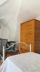 a bedroom with a bed and a wooden cabinet at B&B Vernole1713 in Vernole