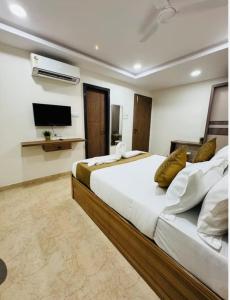a bedroom with a large bed and a flat screen tv at Alwar stay in Alwar