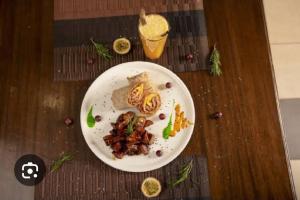 a white plate of food on a wooden table at Alwar stay in Alwar