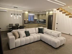 a living room with a white couch and a kitchen at Alykes Maisonette Prv Jacuzzi in Kontokali