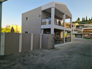 a large building with a fence in front of it at Alykes Maisonette Prv Jacuzzi in Kontokali