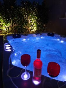 a hot tub with a bottle of wine and two glasses at Alykes Maisonette Prv Jacuzzi in Kontokali