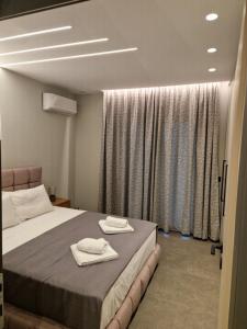 a bedroom with a bed with two towels on it at Alykes Maisonette Prv Jacuzzi in Kontokali +26 photos
