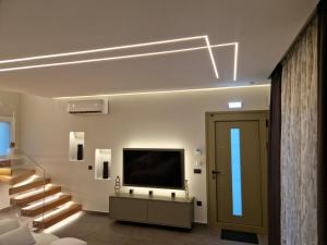 a living room with a television and a staircase at Alykes Maisonette Prv Jacuzzi in Kontokali