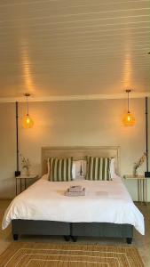 a bedroom with a large white bed with two pillows at Lighthouse Guesthouse & Cafe in Groblersdal +58 photos