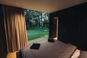 a bedroom with a bed and a large window at Stars Resort Sigulda in Sigulda +103 photos