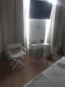 ein Schlafzimmer mit einem Schreibtisch und einem Stuhl neben einem Bett in der Unterkunft Torre Subrosa, vasca in camera cromoterapia in Viterbo