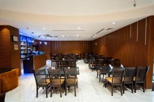 a dining room with tables and chairs and a bar at Smana Hotel Al Raffa in Dubai