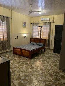 a bedroom with a bed in the middle of a room at Furyan Lodge in Cape Coast