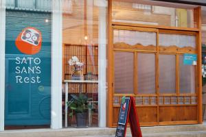 a store with a sign in the window of a store at Sato-san's Rest in Tokyo