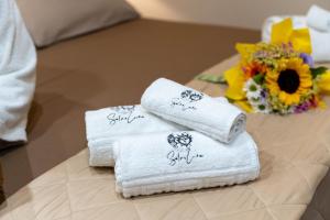 a group of towels sitting on a table with flowers at SOLE e LUNA - JACUZZI e RELAX in Neviano +80 photos
