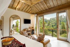 a bedroom with a bed and a balcony at Legong Sebatu Villa in Ubud