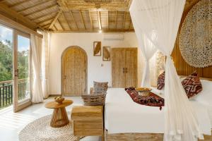 a bedroom with a bed and a balcony at Legong Sebatu Villa in Ubud