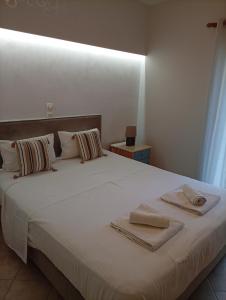 a bedroom with a white bed with towels on it at Danai in Tsoukalades