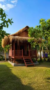 a small hut with two benches in front of it at Garden Cottage in Gili Gede