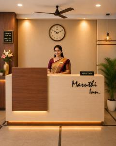 a woman standing behind a counter in a lobby at Maruthi inn hotel in Vijayawāda