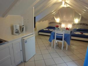 a kitchen with a table and two beds in a room at Botsis Guest House in Hydra