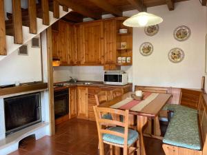 a kitchen with wooden cabinets and a wooden table and chairs at Chalet Iris in Bertigo +22 photos