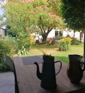 two vases sitting on top of a wooden table at Cabane & Jardin in La Tremblade