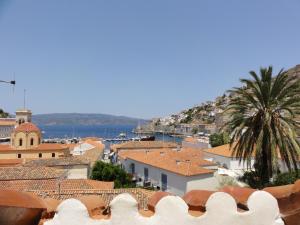a view of a town with a palm tree and buildings at Botsis Guest House in Hydra