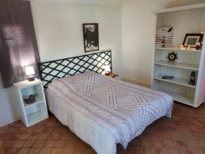 a bedroom with a bed with a white bedspread at Cabane & Jardin in La Tremblade
