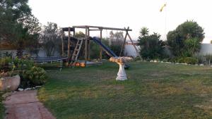 a playground in a yard with a slide at Masada Guest House in Langebaan
