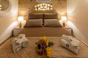 a bedroom with a bed with towels and flowers on it at SOLE e LUNA - JACUZZI e RELAX in Neviano