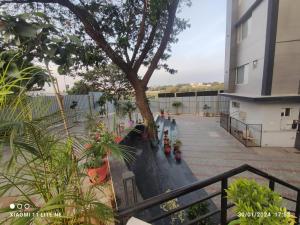 a balcony of a building with a tree and plants at CR RIVERA in Madurai