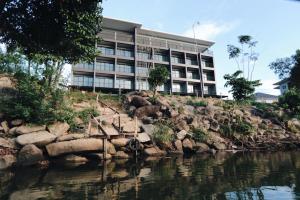 a building on a hill next to a body of water at Riverawan Hotel in Chanthaburi