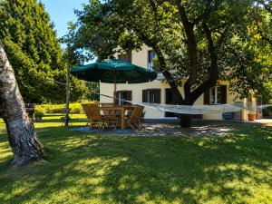 a hammock and a table and chairs under an umbrella at Apartment Piccolo Borgo in Castelveccana